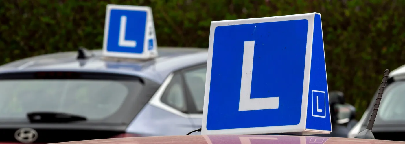 Rijschool leerlingen bij lesauto's op het oefenterrein